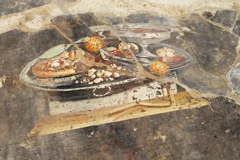 TONY JOLLIFFE/BBC A newly excavated fresco in Pompeii depicting a flatbread that could be the precursor to the modern-day pizza