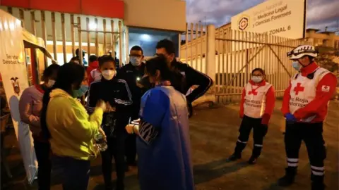 EPA Relatives of murdered inmates await information today outside the forensic centre in the city of Cuenca, Ecuador, 03 April 2022.