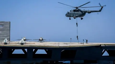 EPA Iranian soldiers jump on the mock carrier