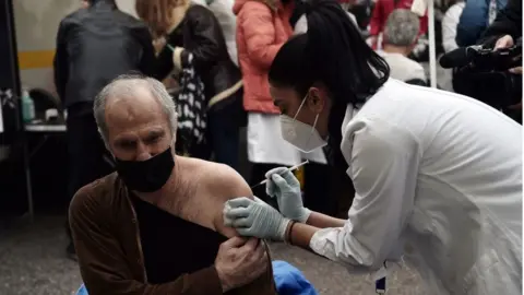 AFP via Getty Images A patient receives a dose of vaccine against Covid-19 in Thessaloniki, Greece