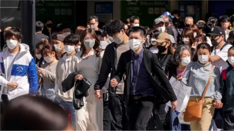 EPA People wearing protective masks walk at a crosswalk at Shibuya In Tokyo, Japan, 18 April 2021.