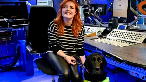 BBC Lucy Edwards and her dog Olga in the Radio 1 studio