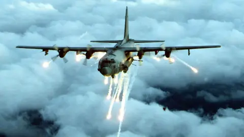Getty Images File photo of an AC-130 gunship firing flares in several directions mid-flight