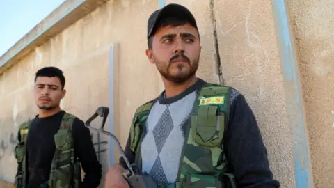 EPA Syrian Democratic Forces fighters take up positions in Ras al-Ain on 10 October 2019