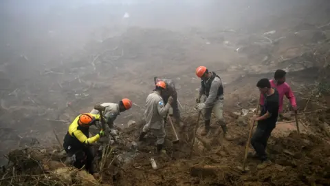 Getty Images Rescue workers search for victims after a giant landslide in Petropolis on 19 February