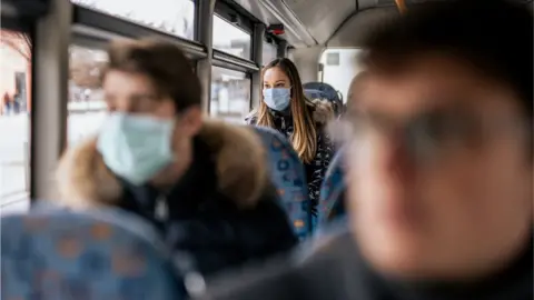 Getty Images passengers wearing masks on a bus