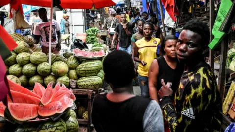 Getty Images People walk at a market without adhering to the rules of social distancing despite the confirmed Covid-19 coronavirus cases in Dar es Salaam, Tanzania, on April 15, 2020.