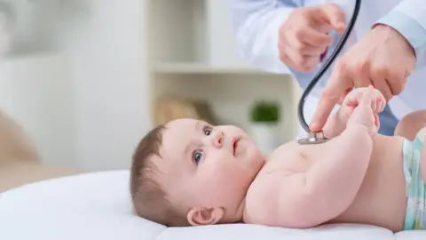 Getty Images A baby being checked by a doctor