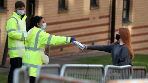 PA Media NHS staff hand out test kits to Glasgow University students