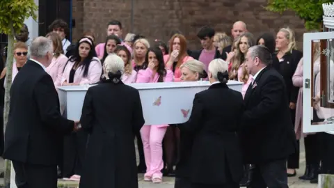 PA Media Mourners wear pink in memory of the nine-year-old