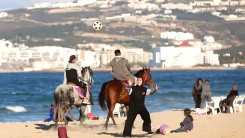Getty Images Football and horses on a beach in Tanger Med in Morocco, Sunday 5 February 2023