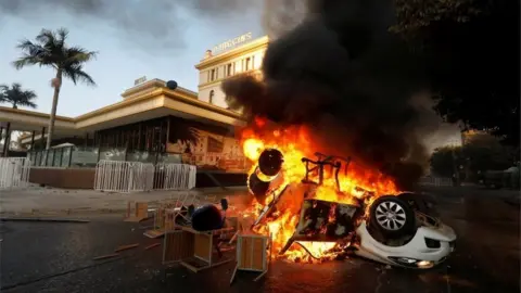 Reuters A car is seen on fire outside the O'Higgins hotel in Viña del Mar