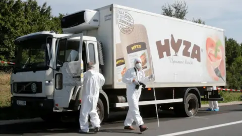 Reuters Forensic police officers inspect a parked truck in which migrants were found dead, on a motorway near Parndorf, Austria August 27, 2015