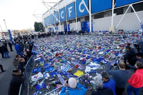 Reuters People look at tributes left outside Leicester City"s King Power stadium, on October 29th 2018