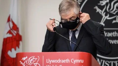 Getty Images Mark Drakeford hosting a news conference wearing a mask during the pandemic