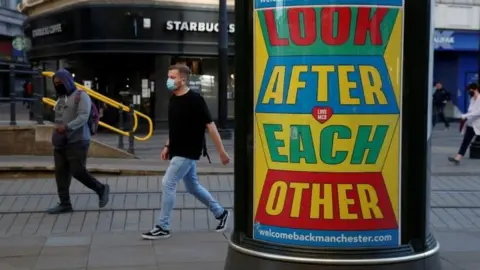 Reuters Coronavirus signage and man wearing mask