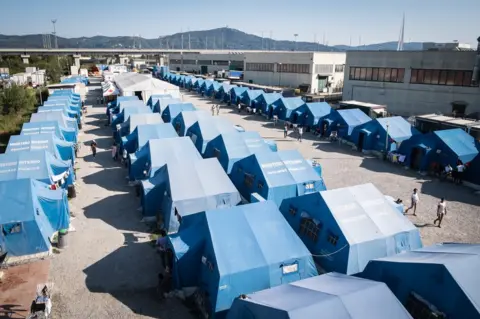 Marco Panzetti A row of blue tents photographed from above.