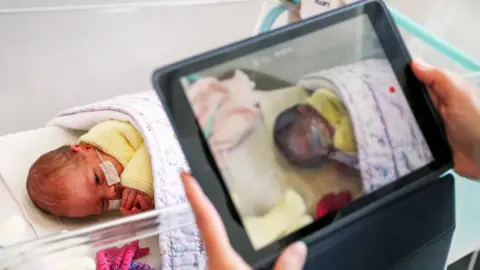 Getty Images A nurse makes a video for new parents because of restricted visiting hours - Surrey, May 2020