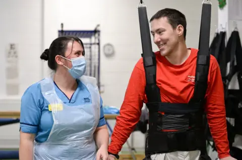 PA Media Luke Louden on the ZeroG Gait and Balance System, pictured with physiotherapist Claire Lincoln