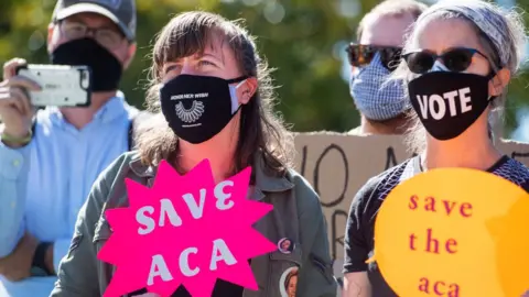 Getty Images Demonstrators calling for a delay in filling the seat of the late Supreme Court Justice Ruth Bader Ginsburg until after the election, are seen during a protest at the Court on third day of the Senate Judiciary Committee confirmation hearing for Supreme Court justice nominee Amy Coney Barrett on Wednesday, October 14, 2020