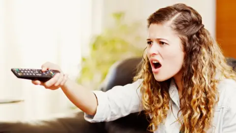 Getty Images Stock image of a woman frustrated with the TV
