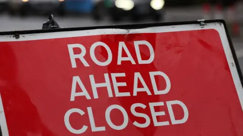 ANDY RAIN/EPA-EFE/REX/Shutterstock Road closure sign