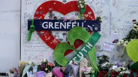 Getty Images Tributes at a memorial at the base of Grenfell Tower, 2018