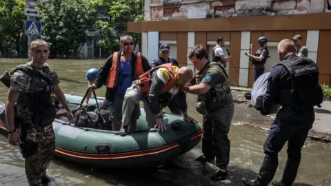 Reuters Police, state emergency service and charity workers have been evacuating people since the dam burst