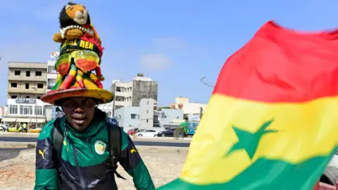 AFP A supporter of Senegal's football team poses with the national flag in Dakar on May 17, 2018, during the announcement of squad members ahead of the forthcoming 2018 FIFA World Cup in Russia