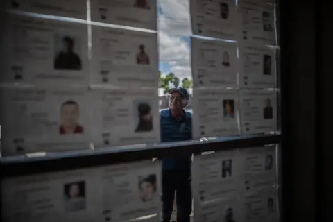 ALEJANDRO CEGARRA Don Pancho is seen looking through the notices of missing people