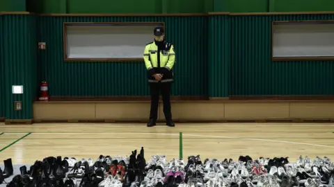 Getty Images Security officer overlooking belongings of victims in Seoul Gym