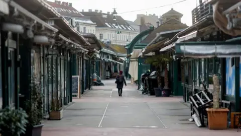 Reuters A lone person walks through a deserted street in the Austrian capital Vienna