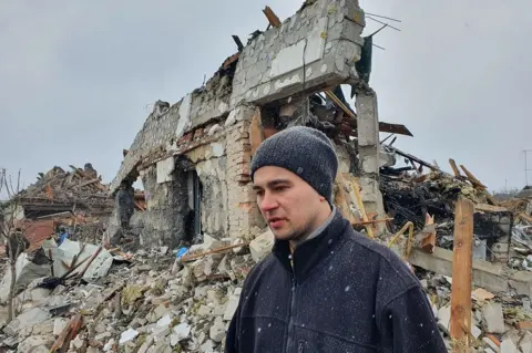 Getty Images A man outside a destroyed building