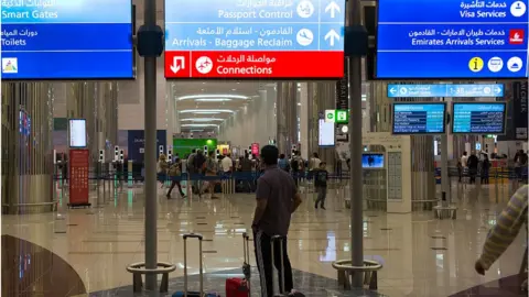 Getty Images A man looks on at the immigration section in the Dubai airport