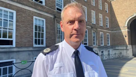 A man with grey hair in a police uniform