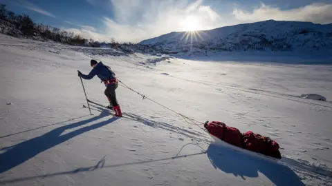 Jason Howard Photography Baz Gray pulling his sled up a hill in the Antarctic