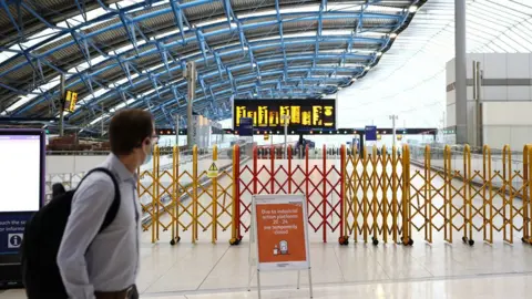 Reuters A commuter walking past a closed concourse inside Waterloo Station during the national rail strikes