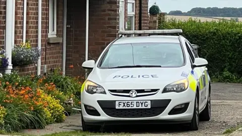 BBC/Caroline Bilton Police car at scene