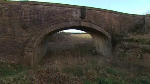 BBC Image shows the "missing mile" section of the Stroudwater canal overgrown and under a bridge