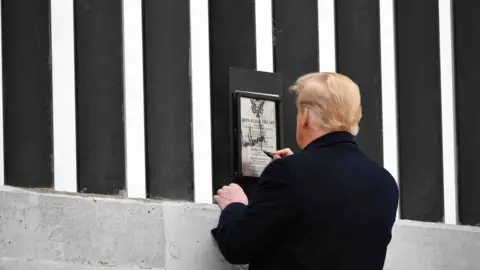 AFP via Getty Images US President Donald Trump tours and signs a section of the border wall in Alamo, Texas