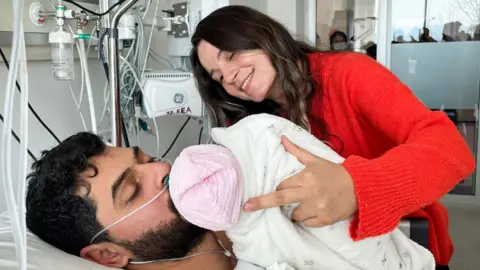 Anadolu Agency Mustafa Avci kissing his baby in hospital after being rescued 261 hours after quake