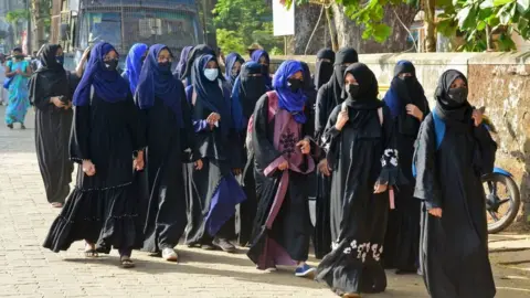 Getty Images Students of government Pre-University college in Kundapur town wearing hijab arrive at their college in Udupi district in India's Karnataka state on February 7, 2022.