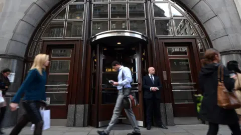 Getty Images staff walk past Goldman Sachs offices