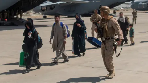 MoD UK Armed Forces leading evacuees at Kabul airport