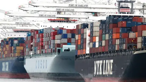 Getty Images Container ships are positioned under cranes at the Port of Oakland