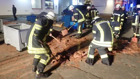 Reuters Firefighters clear chocolate