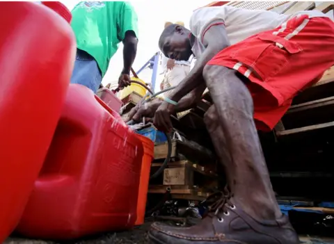 Paul Blake/BBC Collecting petrol in a can in Tortula