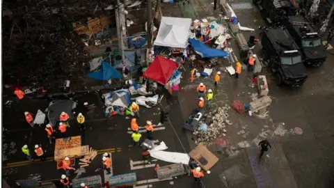 Getty Images Municipal workers clean up Chop zone in Seattle. Photo: 1 July 2020