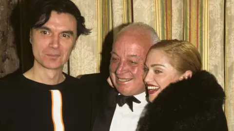 Getty Images Talking Heads' David Byrne, Seymour Stein and Madonna at the 11th Annual Rock and Roll Hall of Fame Induction Dinner, 1996