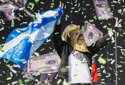 PA Media Lewis Capaldi takes to the main stage wearing a Chewbacca mask